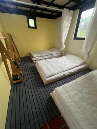 a room with three beds in a room at Fish Farm Homestay in Yên Bái