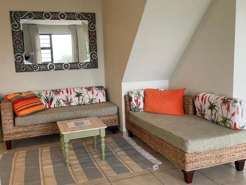 a living room with two couches and a mirror at Coast B&B - Agulhas in Agulhas
