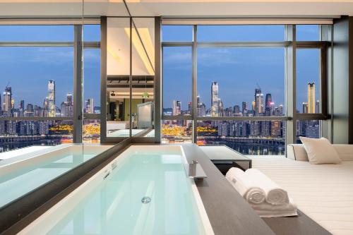 a large bathroom with a pool and a view of the city at 重庆Indition英迪逊酒店江北嘴金融城店 in Chongqing