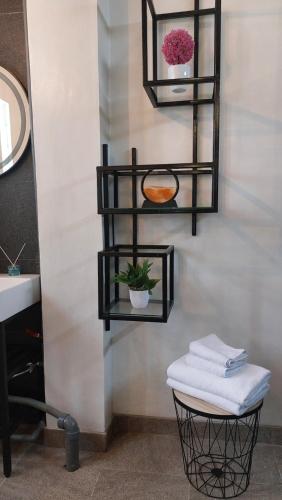 a bathroom with black shelves with towels and a sink at Valhalla Boutique Hotel in Salatiga