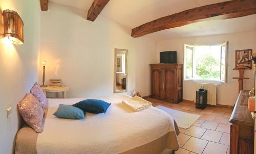 une chambre avec un grand lit avec des oreillers bleus dans l'établissement Maison de Caractère située au coeur des domaines viticoles de BANDOL, à La Cadière-dʼAzur