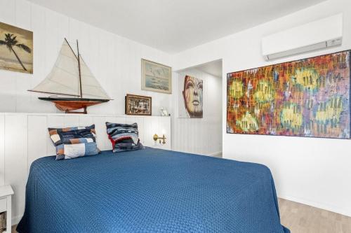 - une chambre avec un lit bleu et un voilier sur le mur dans l'établissement Centre-ville-Proche des plages-Wifi-Clim, à Saint-Raphaël