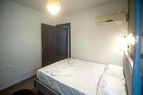 a bedroom with a white bed and a window at Ikaria Studios in Agios Kirykos