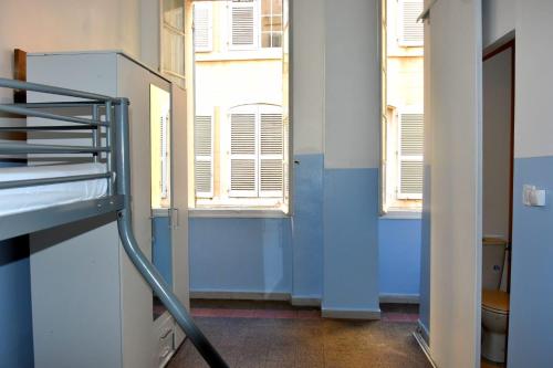 a room with blue walls and windows and a ladder at Hotel THEFFA in Marseille