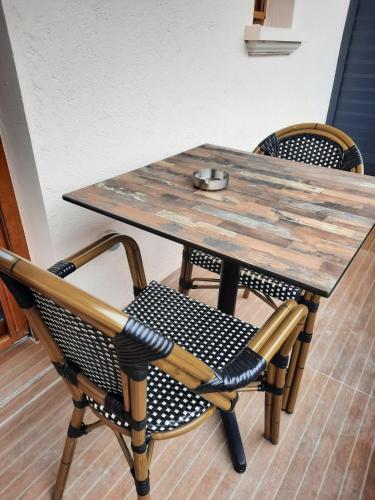 une table en bois avec deux chaises et une table et des chaises en bois dans l'établissement Nuit Express à Love Suite L'Origin'El d'Ornans, à Ornans