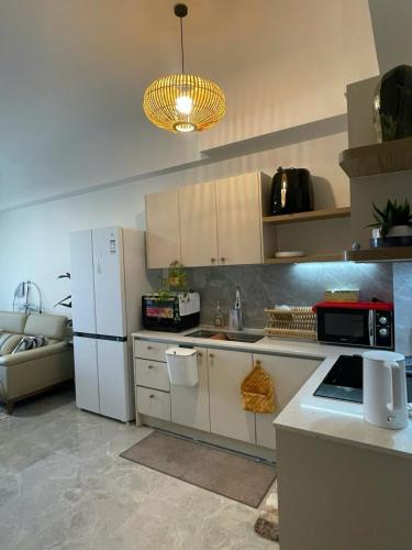 a kitchen with white cabinets and a white refrigerator at Swanbay Heaven in Nhơn Trạch
