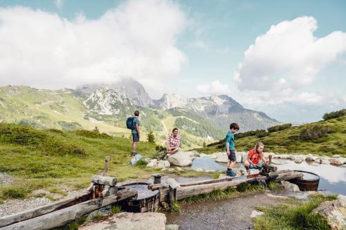 a group of people sitting on a bridge in the mountains at Falkensteiner Family Hotel Sonnenalpe in Sonnenalpe Nassfeld