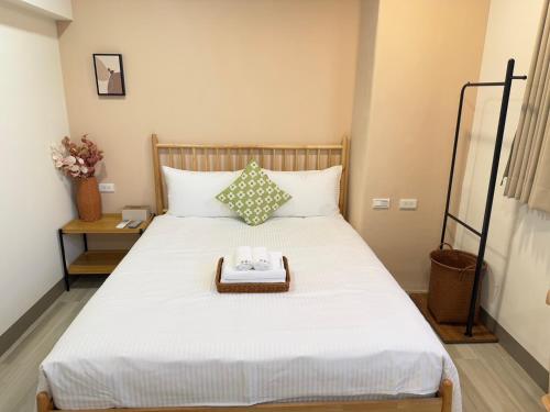 a bed with a tray with two towels on it at Lin's House in Ch'ih-k'an-lou