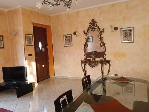 a dining room with a glass table and a mirror at La Casa di Laura in Ciriè