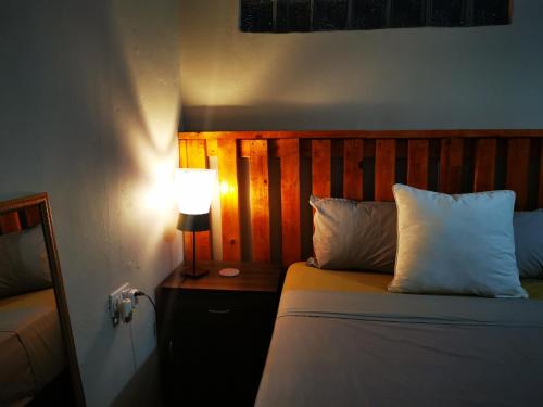 a bedroom with a bed with a lamp on a table at Gwanxhae Boutique Accommodation in Maun