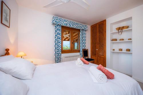 a bedroom with a white bed and a window at Villa Carla in Port de Soller