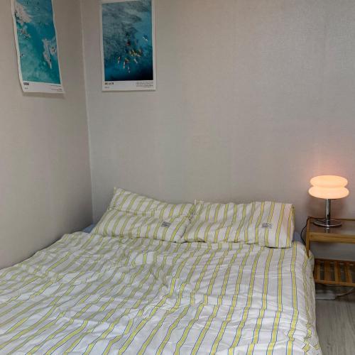 a bedroom with a bed and a lamp on a table at Yongridan-gil House in Seoul