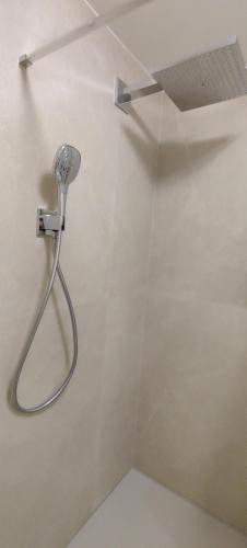 a shower with a shower head in a bathroom at Recent vernieuwd appartement met zeezicht en een gratis parkeerplaats in Koksijde