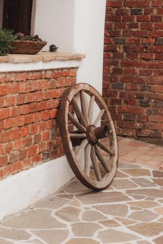a wooden wagon wheel leaning against a brick wall at Südburgenland Vierkanthof in Doiber