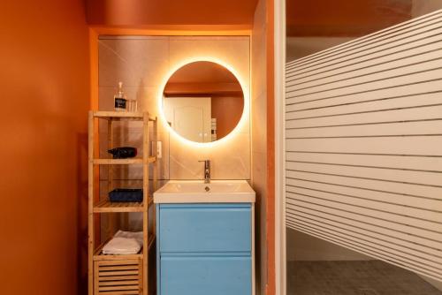 une salle de bain avec un lavabo et un miroir dans l'établissement T2-Centre-ville-Parking, à Pontchâteau