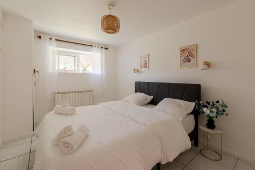 - une chambre avec 2 serviettes blanches sur un lit dans l'établissement T2-Centre-ville-Parking, à Pontchâteau