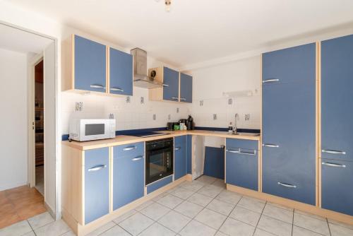 - une cuisine avec des placards bleus et un four micro-ondes dans l'établissement T2-Centre-ville-Parking, à Pontchâteau