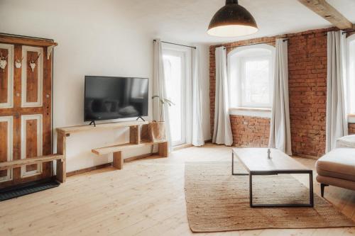 a living room with a couch and a tv at Südburgenland Vierkanthof in Doiber