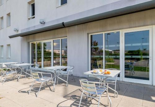 a group of tables and chairs on a patio at B&B HOTEL Lyon Eurexpo Chassieu in Chassieu