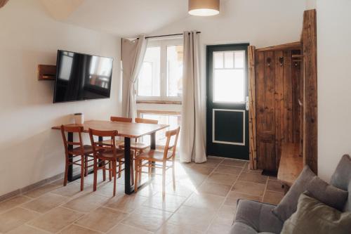 a dining room with a table and chairs and a tv at Südburgenland Vierkanthof in Doiber