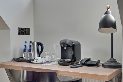 a table with a coffee maker and a lamp on it at HOTEL ALMOND BUSINESS & SPA BY GRANO - GRANO HOTEL Gdańsk Riverside in Gdańsk