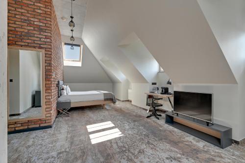 a living room with a bed and a television at HOTEL ALMOND BUSINESS & SPA BY GRANO - GRANO HOTEL Gdańsk Riverside in Gdańsk