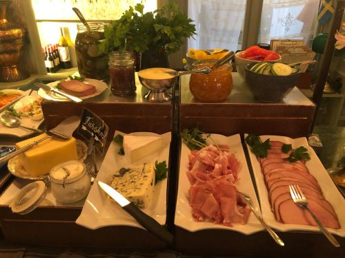 a table topped with different types of meats and cheese at Strandflickornas Annex Gula Villan in Lysekil