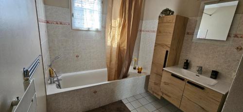 une salle de bain avec une baignoire et un lavabo dans l'établissement Appartement entier Lyon-Villeurbanne au 1er d'une discrète maison, à Villeurbanne
