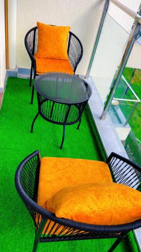 two chairs and a table on a balcony with green grass at Caster two bedrooms apartment jkia in Nairobi