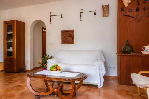 Una sala de estar con un sofá blanco y una mesa. en Es Quarteró, en Sóller