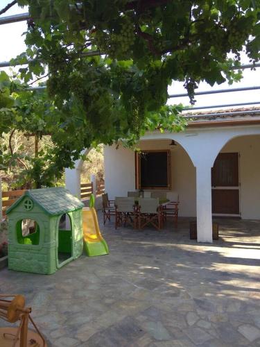a green play house with a slide in front of a house at Oνειροπαγίδα in Ayia anna