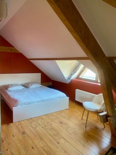une chambre avec un lit et une chaise dans l'établissement APPARTEMENT COSY 40 m2, climatisé, parking gratuit, à Annecy