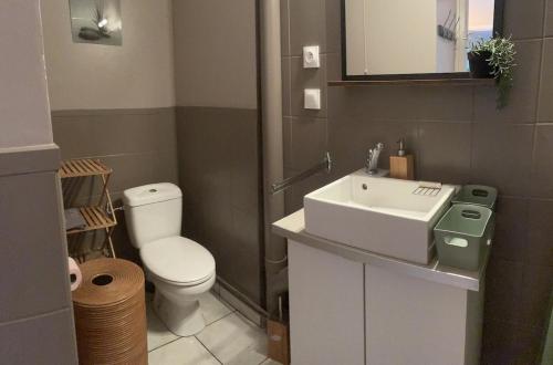 a bathroom with a white sink and a toilet at chez Nadège in Floing