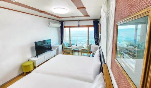 a bedroom with a bed and a large window at Jeju Yongdam House in Jeju