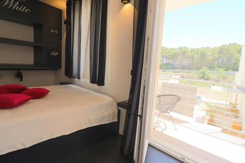 een kleine slaapkamer met een bed en een balkon bij Suite Black and White in Otranto