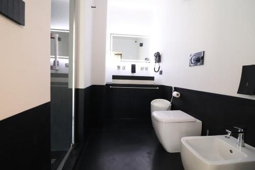 een zwart-witte badkamer met een toilet en een wastafel bij Suite Black and White in Otranto