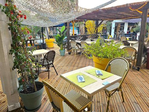a wooden deck with tables and chairs and plants at Malibu Village in Canet-en-Roussillon