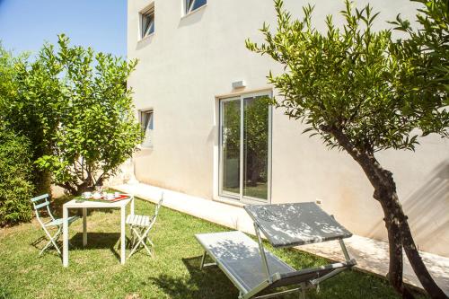 a garden with a table and chairs and a tree at Wp Relais apartments in Diso