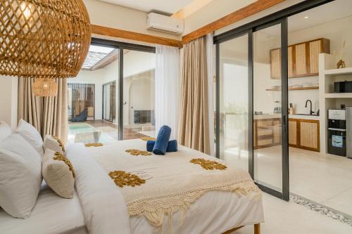 a bedroom with a large bed with a large window at La Tropical Uluwatu, Bingin in Uluwatu