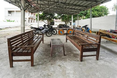 a group of motorcycles parked under a pavilion at Hotel O Penginapan Indah Permai Syariah in Tanjungraya