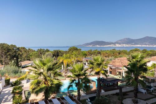 an aerial view of a resort with palm trees at Bella Vista Hôtel, Suites & Maisons in Porticcio
