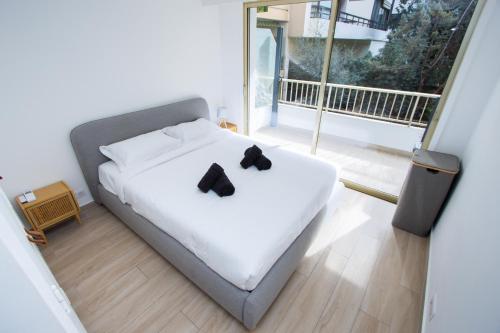 une chambre avec un lit avec deux nœuds papillon noirs dessus dans l'établissement Spacieux T2 avec grande terrasse à 200m de la plage, à Cannes