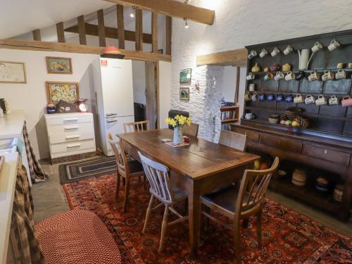 a dining room with a wooden table and chairs at Tipyn Bach in Caerphilly