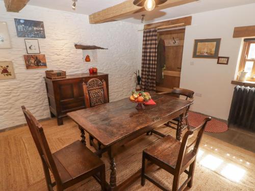 a dining room with a wooden table and chairs at Tipyn Bach in Caerphilly