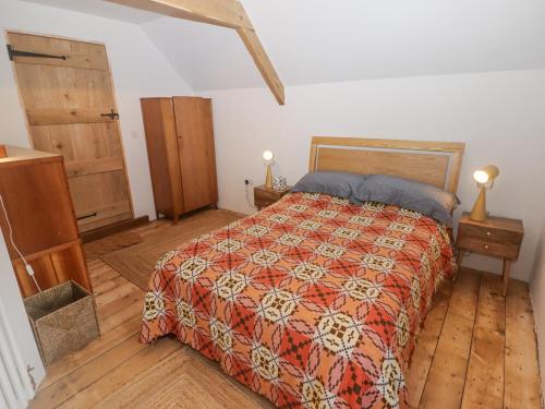 a bedroom with a bed and a wooden floor at Tipyn Bach in Caerphilly