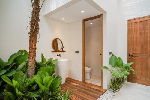 a bathroom with a toilet and some plants at La Tropical Uluwatu, Bingin in Uluwatu