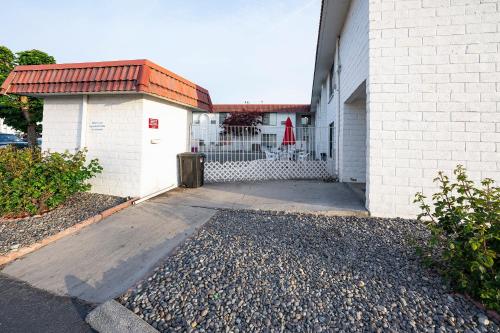 a white building with a gate and a driveway at OYO Hotel Hermiston OR, Downtown in Hermiston