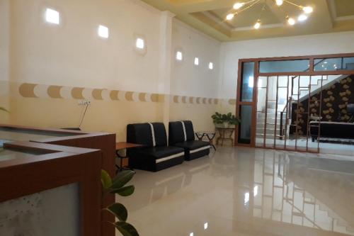 a living room with two chairs and a staircase at OYO 91162 Homestay Ansyariah Syariah in Palu
