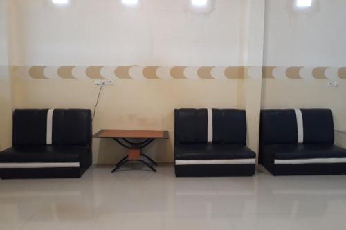 a waiting room with two chairs and a table at OYO 91162 Homestay Ansyariah Syariah in Palu
