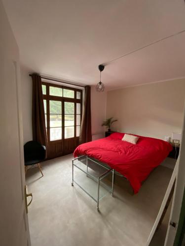 - une chambre avec un lit rouge et une fenêtre dans l'établissement Appartement à la montagne, à Moutiers